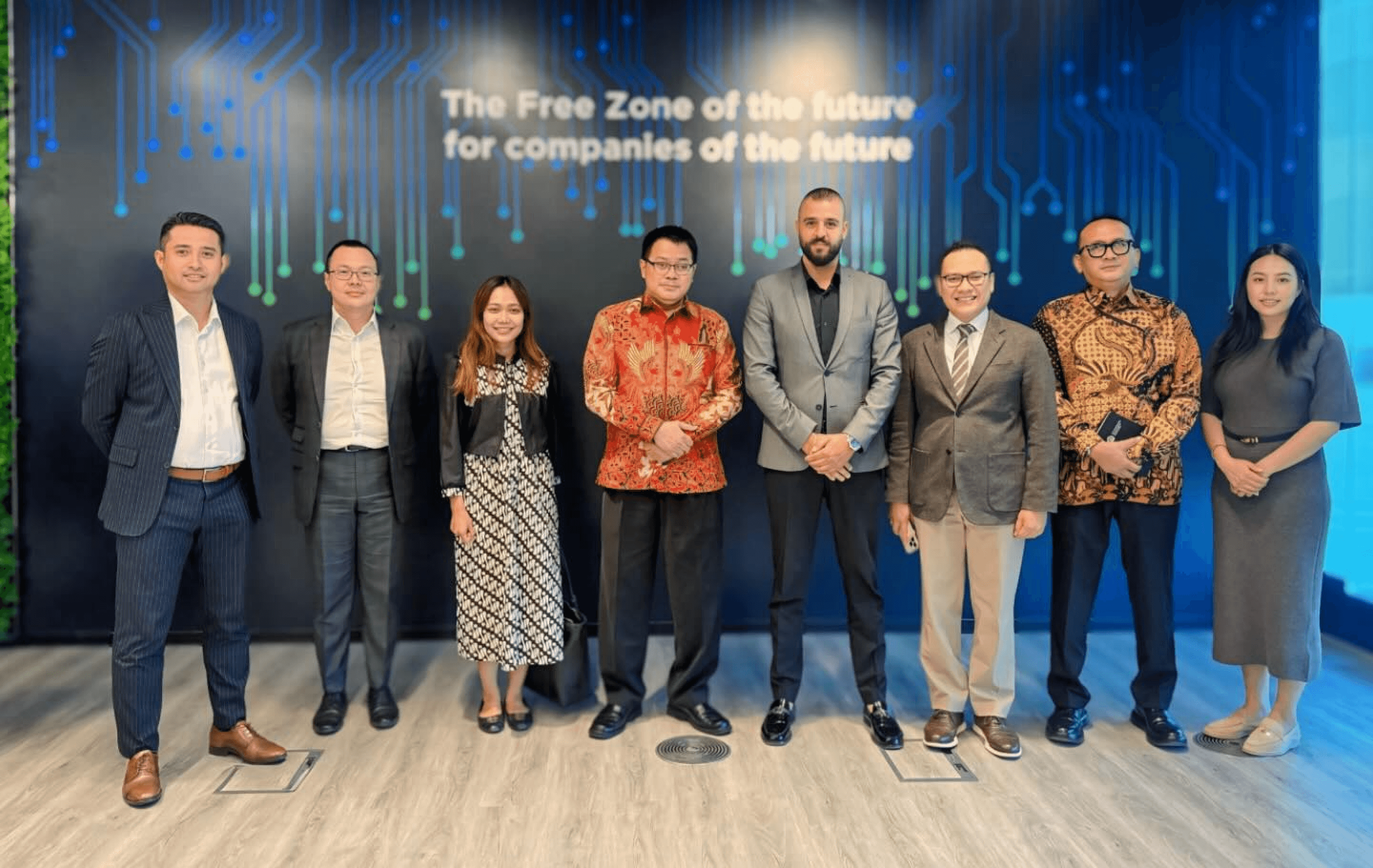 Business delegation visiting Innovation City in front of the “Free Zone of the future” wall
